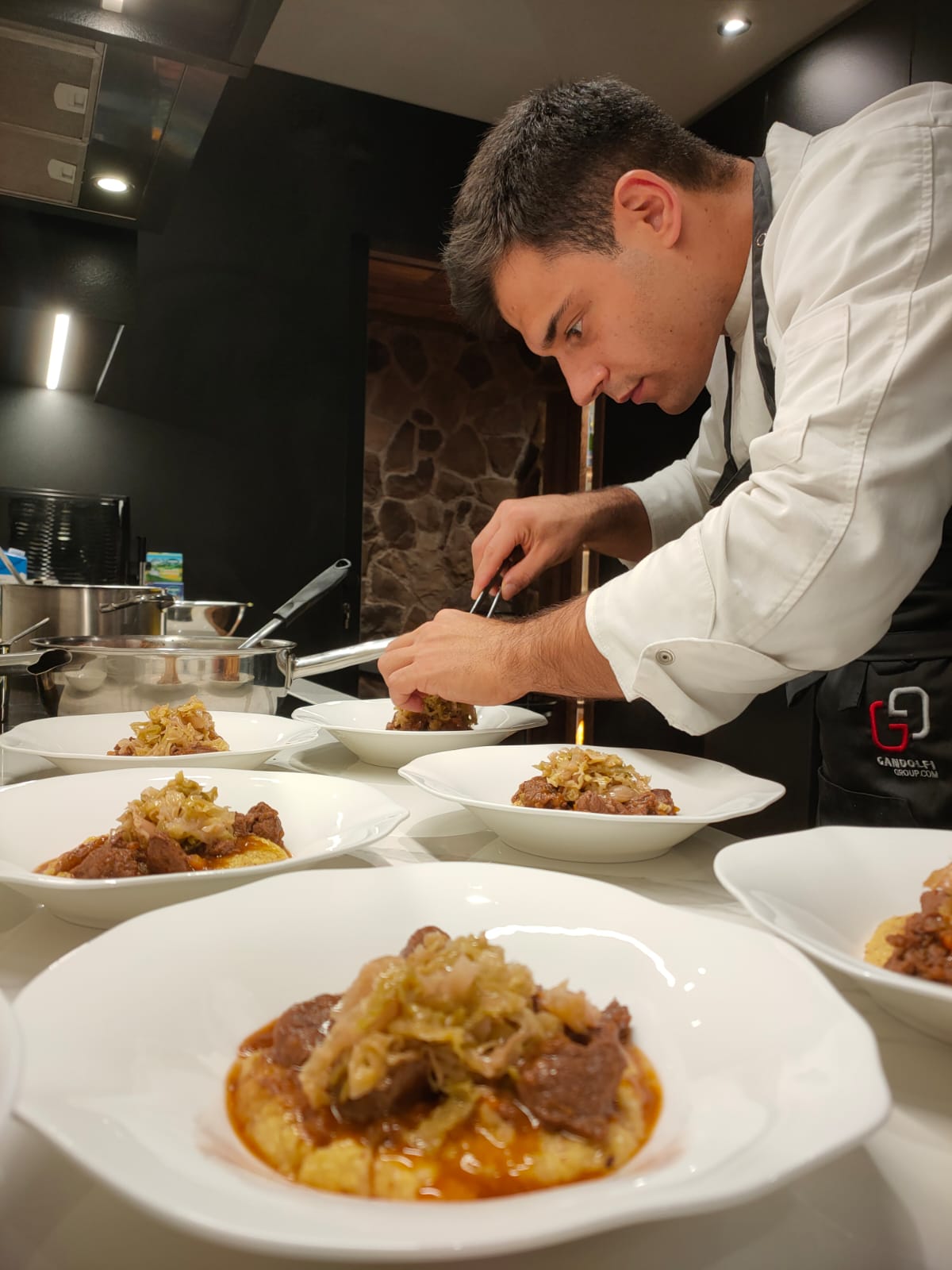 Lorenzo finishing dishes with tweezers during service